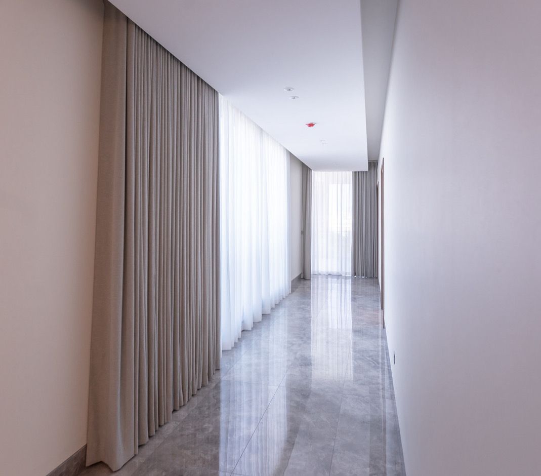 Full-height wave-fold curtains along a villa corridor, Dubai